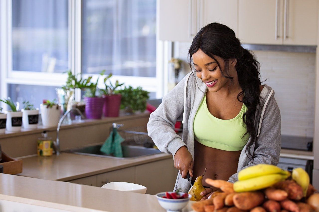 woman cutting fruit in the kitchen lose weight