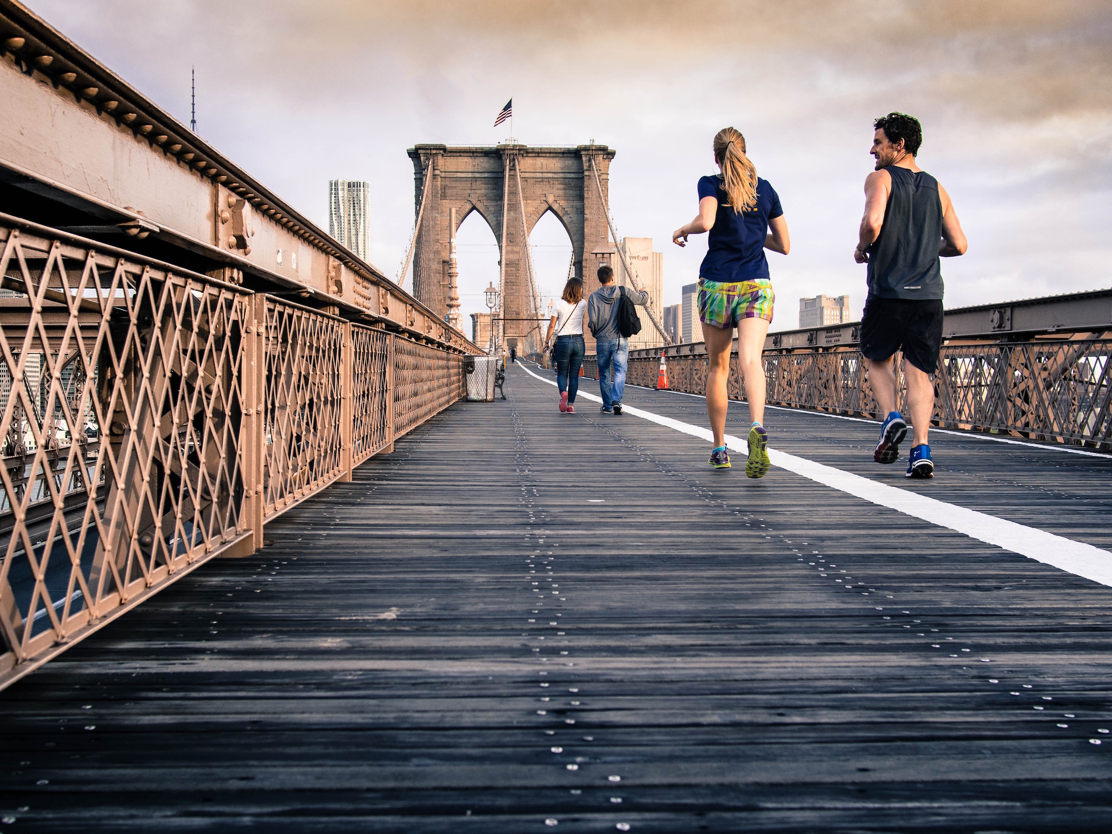 man and women running on bridge