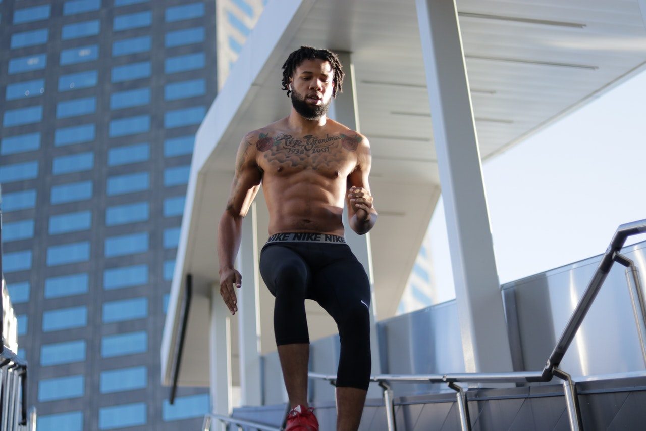shirtless ripped man jogging down stairs