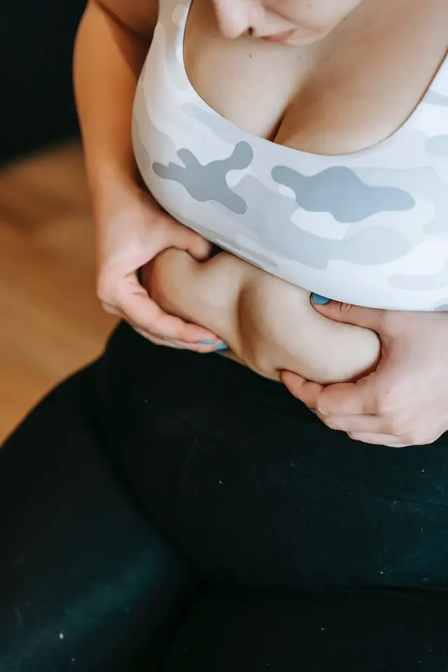Woman touching abdomen during exercise training.