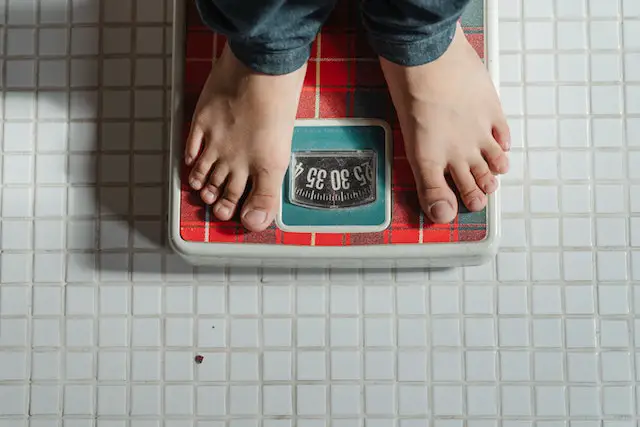 Standing on a bathroom scale to check weight loss