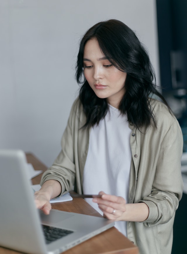 Woman using a credit card while online shopping.