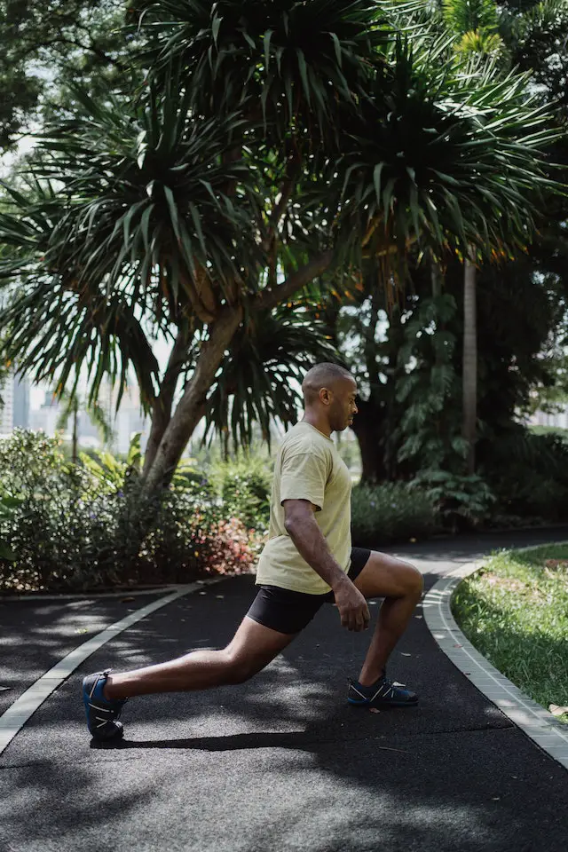 A man doing lunges outdoors.