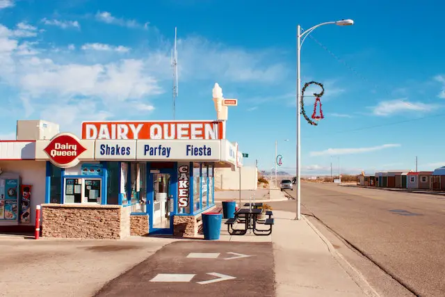 A picture of Dairy Queen restaurant beside a road.