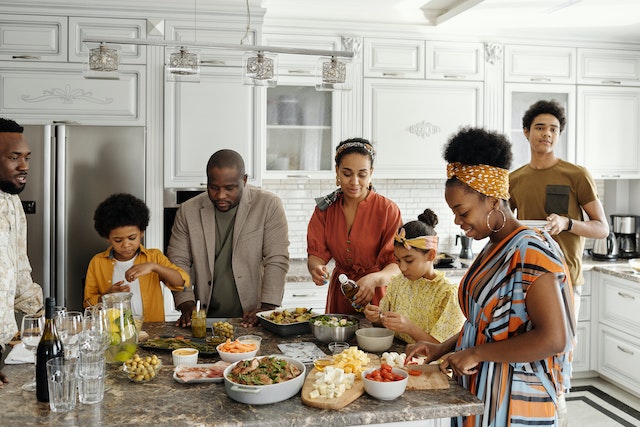 A happy helping out each other to prepare food in the kitchen for thanksgiving dinner.