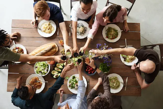 A group of people making a toast over thanksgiving dinner.