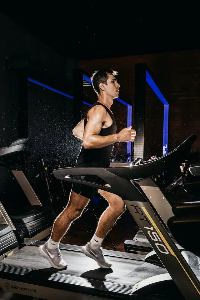 A muscular man running on a treadmill.