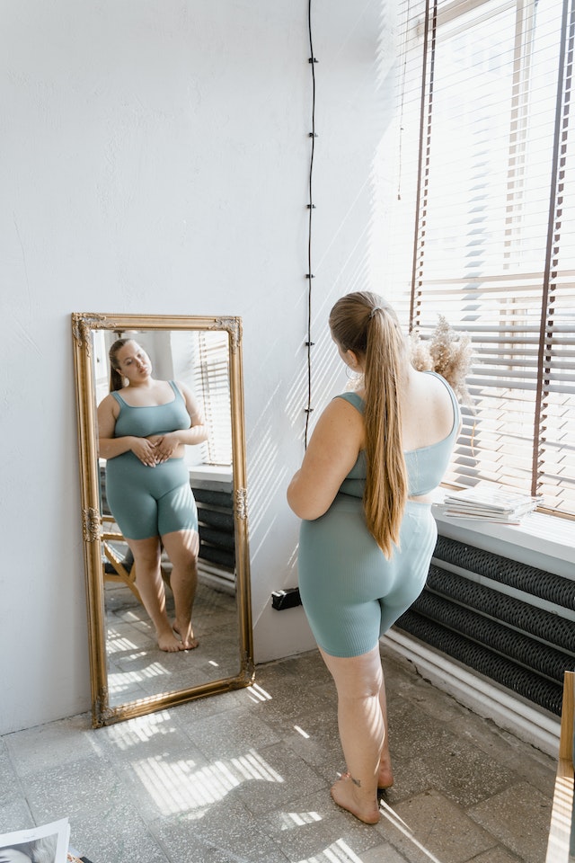 A woman looking at herself in a mirror.