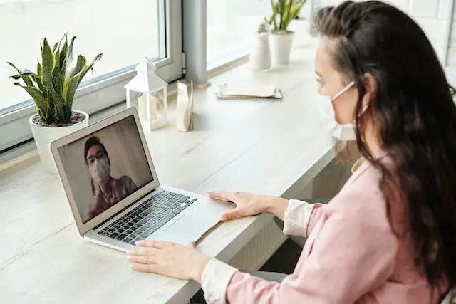 A woman having an online consultation with her doctor.
