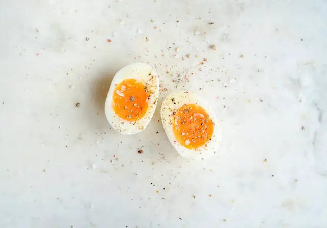 Halved soft-boiled egg sprinkled with crushed spices.