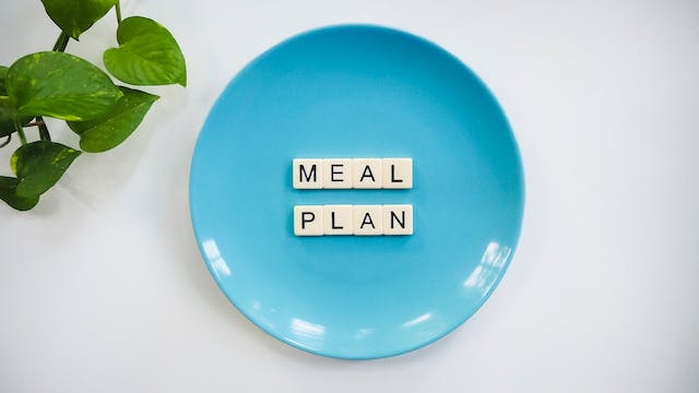 A tiled word "MEAL PLAN" on a blue plate.