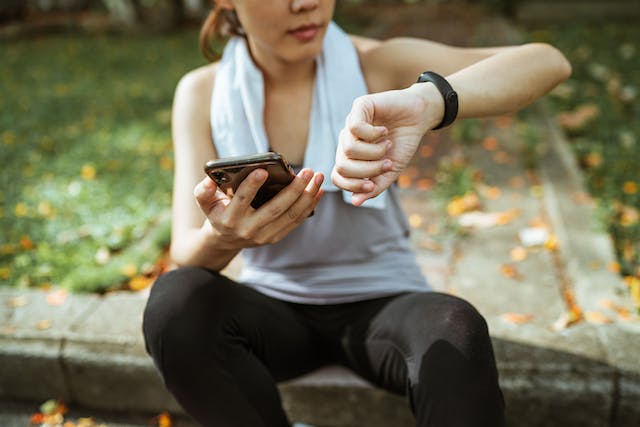 A woman using her smart phone and smart watch.