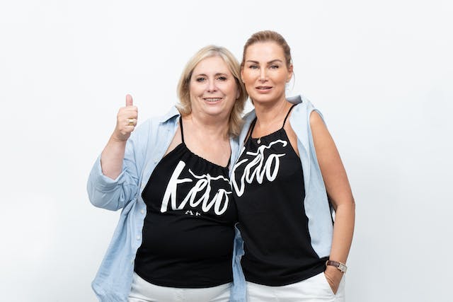Two women wearing a black spaghetti top that says "keto."