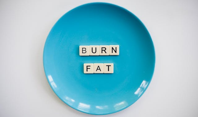 A blue plate with scrabble tiles saying "burn fat"