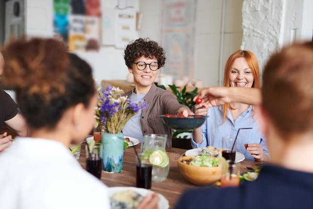 A group of people sharing food at the dining room.